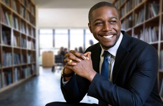 Black lawyer smiling inside a law library and resource documents